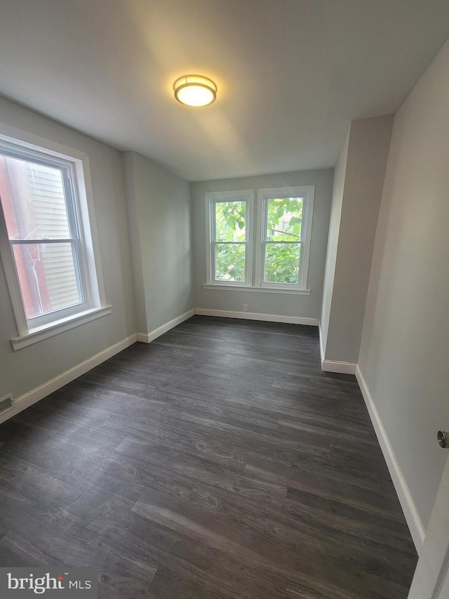 unfurnished room featuring dark wood-type flooring