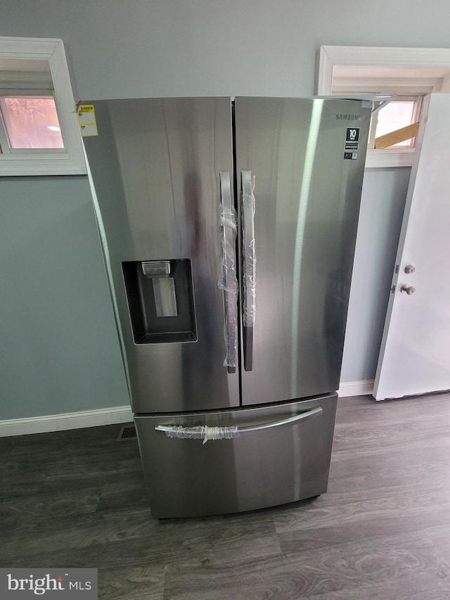 kitchen featuring plenty of natural light, dark hardwood / wood-style flooring, and stainless steel fridge with ice dispenser