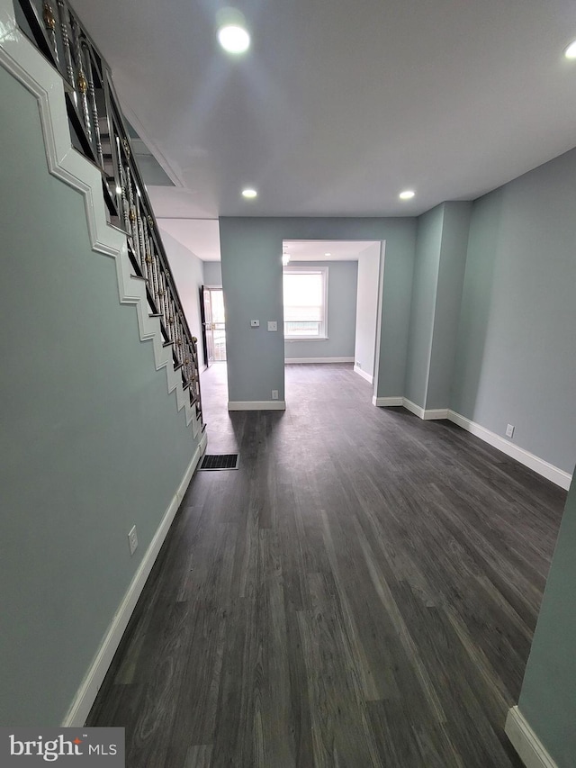 unfurnished living room featuring dark wood-type flooring