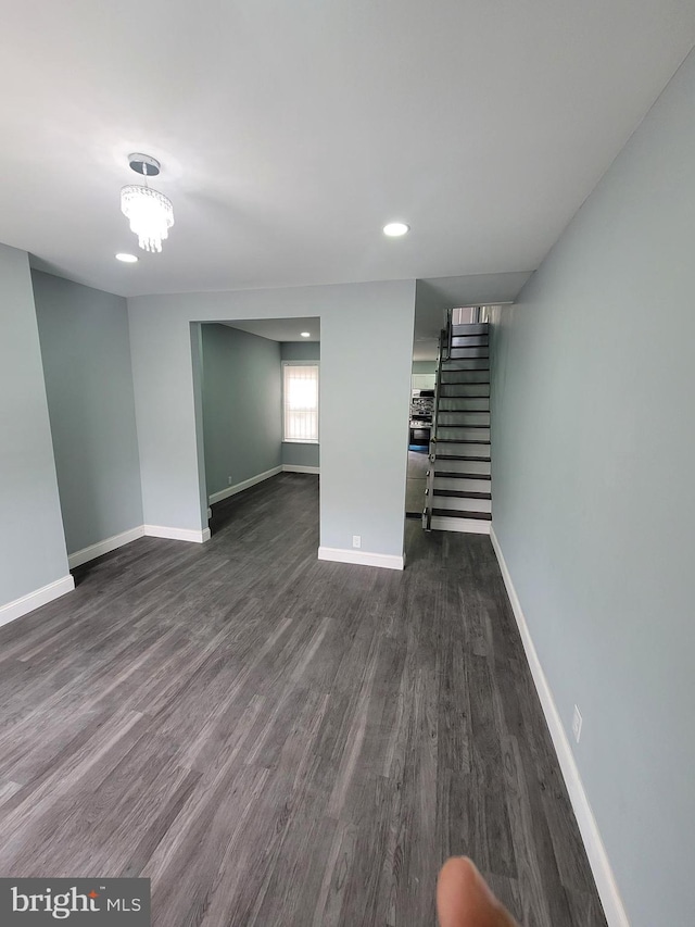 basement featuring an inviting chandelier and dark wood-type flooring