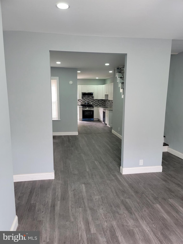 unfurnished living room featuring dark hardwood / wood-style flooring and sink