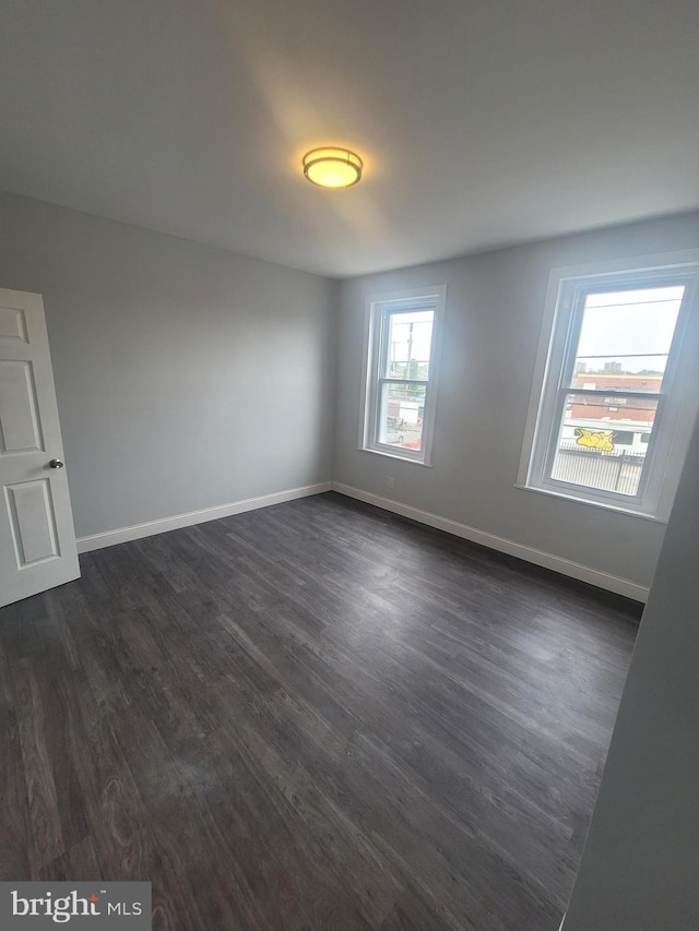 spare room featuring dark wood-type flooring