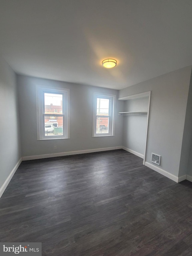 unfurnished bedroom with dark wood-type flooring