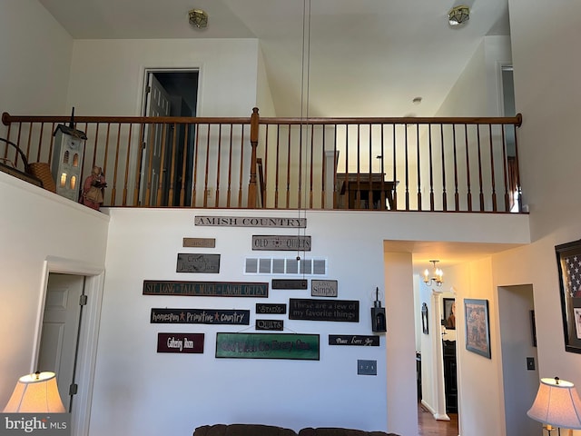 stairway featuring a towering ceiling and a notable chandelier