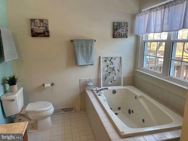 bathroom featuring toilet, tile patterned floors, tiled tub, and vanity