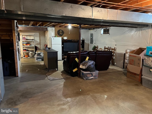 basement with electric panel and white refrigerator