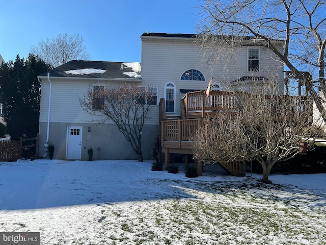 snow covered property with a wooden deck