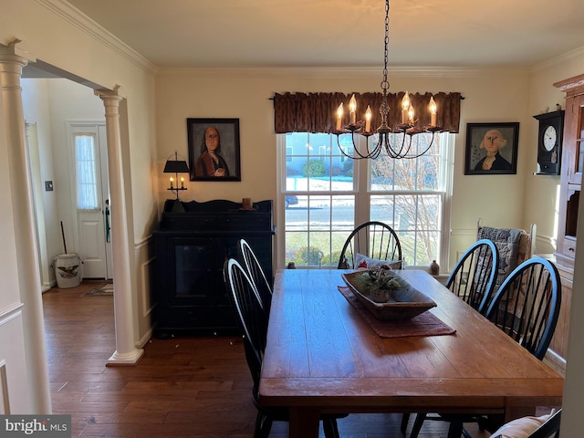 dining room with decorative columns, crown molding, a chandelier, and dark hardwood / wood-style floors