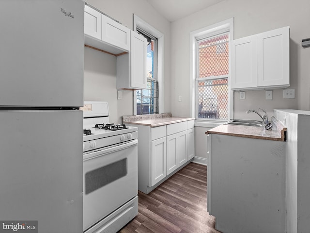 kitchen featuring dark hardwood / wood-style flooring, white appliances, white cabinetry, and sink