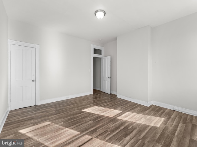 empty room with dark hardwood / wood-style flooring