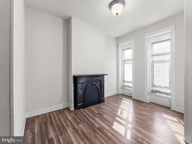 unfurnished living room featuring dark hardwood / wood-style flooring and a wealth of natural light