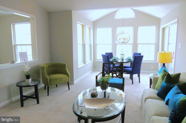 carpeted living room with lofted ceiling, an inviting chandelier, and plenty of natural light