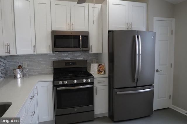 kitchen with backsplash, stainless steel appliances, light stone countertops, and white cabinets