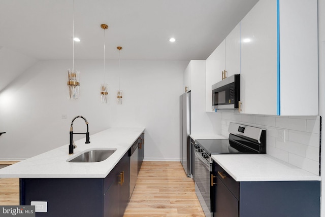 kitchen with stainless steel appliances, sink, white cabinetry, tasteful backsplash, and hanging light fixtures