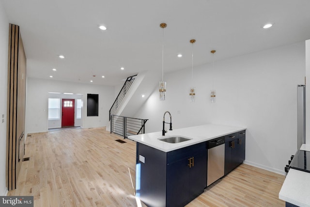 kitchen with stainless steel dishwasher, sink, pendant lighting, and light hardwood / wood-style flooring