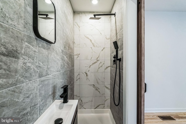 bathroom with a tile shower and sink