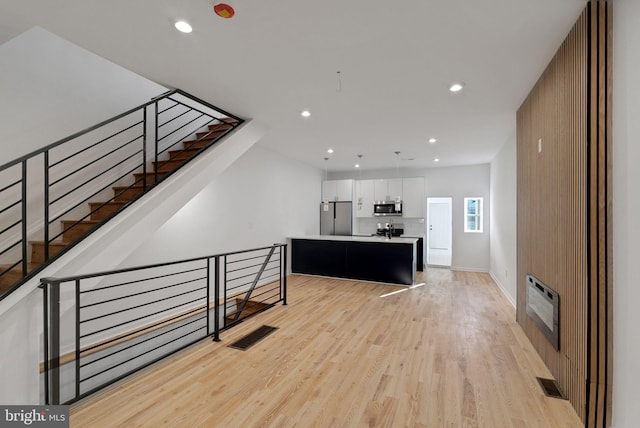 interior space with sink, hardwood / wood-style floors, and heating unit