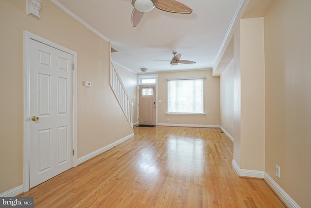 foyer entrance featuring ceiling fan, crown molding, and light hardwood / wood-style flooring