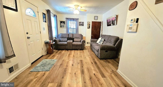 living room featuring ceiling fan and light wood-type flooring