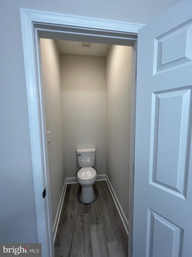 bathroom featuring wood-type flooring and toilet