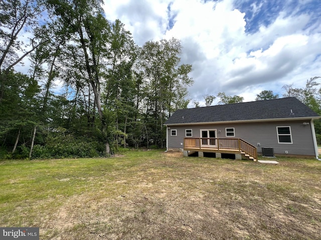 rear view of property with central AC unit, a deck, and a yard