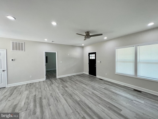 unfurnished living room featuring ceiling fan and light hardwood / wood-style floors