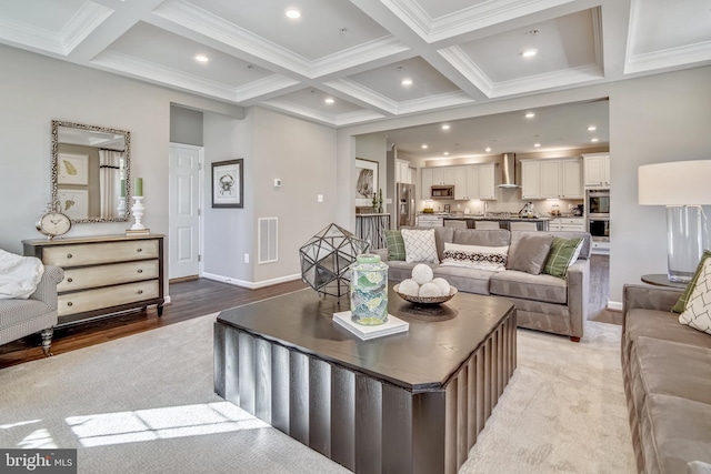 living room featuring beam ceiling, light wood-type flooring, ornamental molding, and coffered ceiling