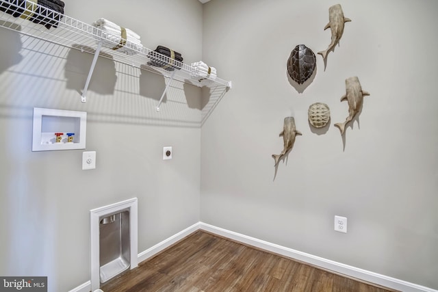 clothes washing area featuring electric dryer hookup, hookup for a washing machine, and hardwood / wood-style flooring