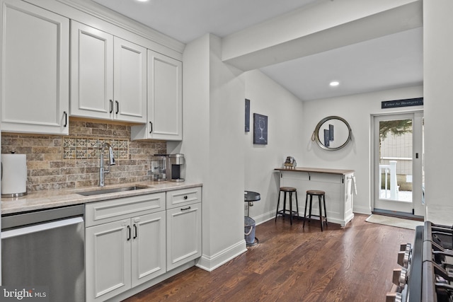 kitchen with decorative backsplash, dark hardwood / wood-style flooring, stainless steel dishwasher, sink, and white cabinetry