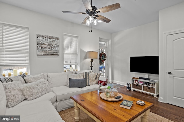 living room featuring ceiling fan and dark wood-type flooring