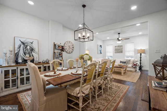 dining area featuring ceiling fan with notable chandelier and dark hardwood / wood-style floors