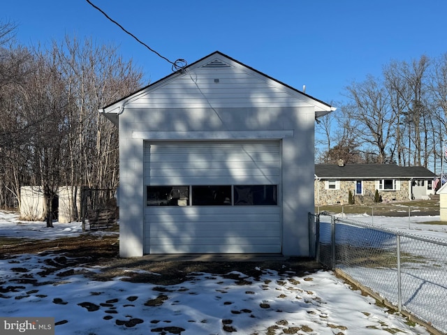 view of snow covered exterior with a garage and an outdoor structure