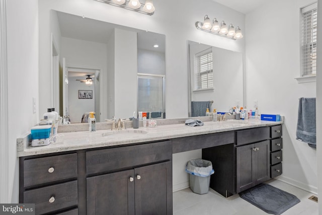 bathroom with ceiling fan, vanity, a shower with door, and tile patterned floors