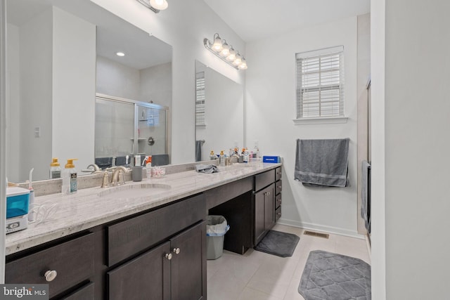 bathroom featuring a shower with shower door, tile patterned floors, and vanity