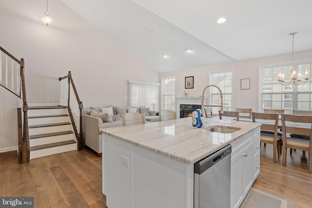 kitchen featuring dishwasher, pendant lighting, sink, an island with sink, and white cabinets