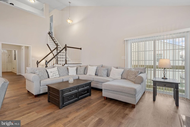 living room with high vaulted ceiling and hardwood / wood-style floors