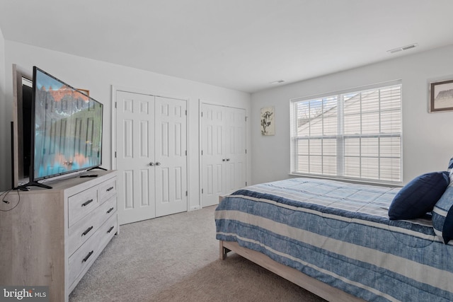 carpeted bedroom with multiple closets