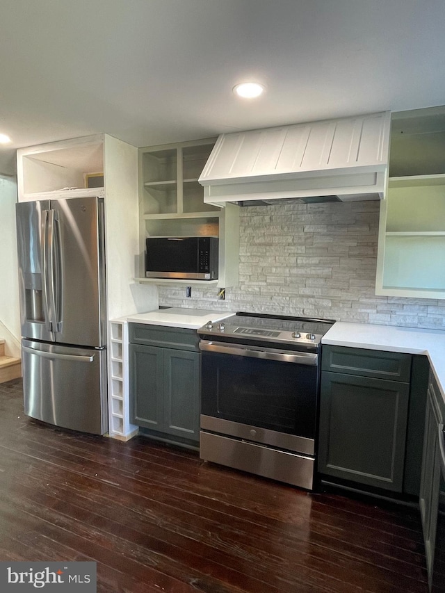 kitchen featuring gray cabinets, appliances with stainless steel finishes, dark hardwood / wood-style flooring, decorative backsplash, and custom range hood