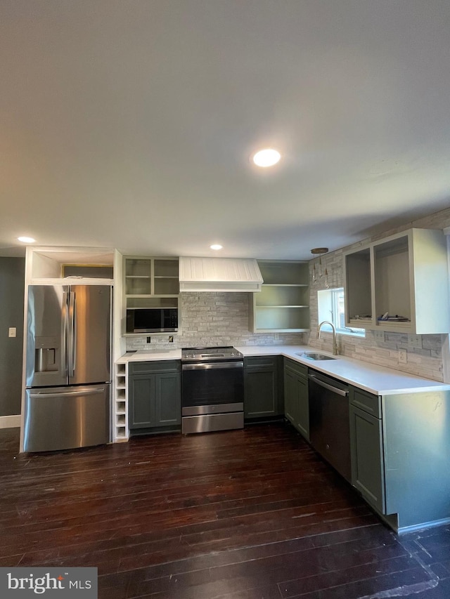 kitchen featuring premium range hood, sink, backsplash, stainless steel appliances, and dark wood-type flooring