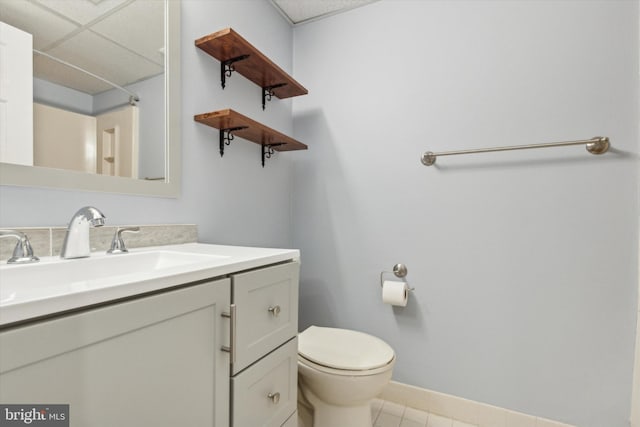 bathroom featuring tile patterned flooring, vanity, and toilet