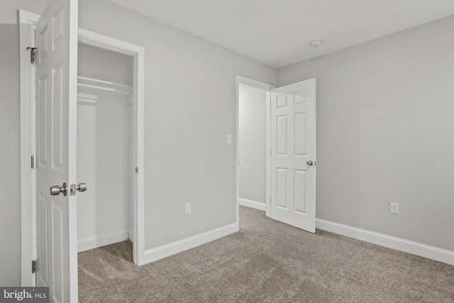 unfurnished bedroom with light carpet and a closet