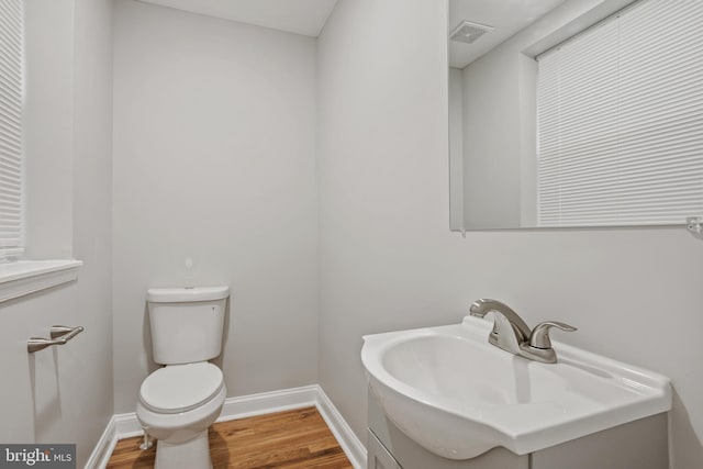 bathroom with wood-type flooring, toilet, and sink