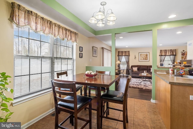 tiled dining area featuring a notable chandelier and sink