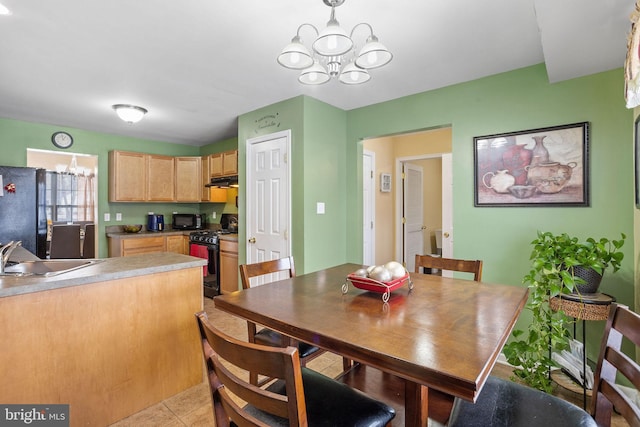 dining area with light tile patterned flooring, sink, and an inviting chandelier