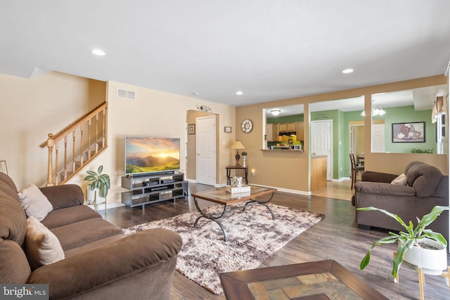 living room with dark hardwood / wood-style flooring and an inviting chandelier