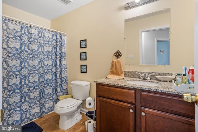 bathroom featuring tile patterned floors, vanity, and toilet