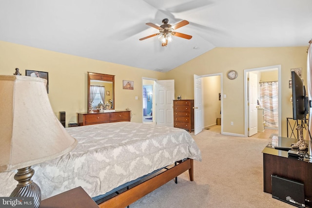 bedroom with ceiling fan, lofted ceiling, light carpet, and connected bathroom