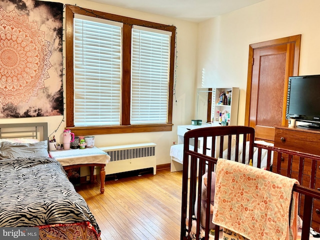 bedroom with radiator and light hardwood / wood-style floors