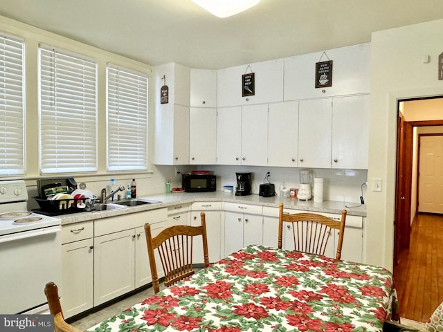 kitchen featuring decorative backsplash, sink, white cabinets, and white electric stove