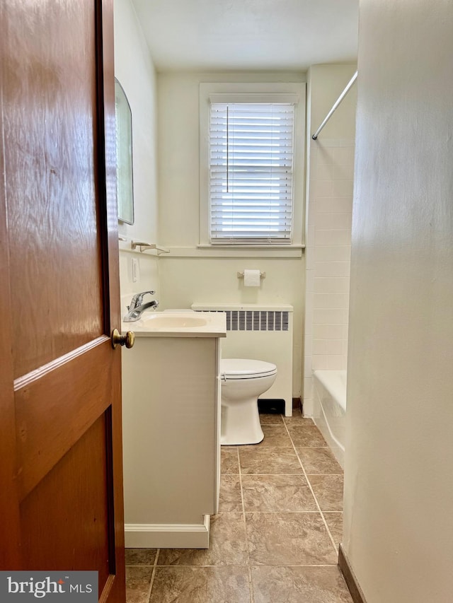 full bathroom featuring toilet, vanity, radiator heating unit, and tiled shower / bath